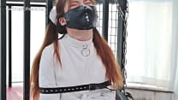 Straitjacket bondage of an Asian woman wearing a latex catsuit